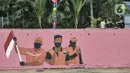 Warga duduk dekat mural bertema HUT ke-75 RI yang menghiasi jalan di Kampung Melayu, Jakarta, Minggu (16/8/2020). Jelang HUT ke-75 RI, mural bernuansa Merah Putih banyak menghiasi jalanan Ibu Kota guna memberi semangat nasionalisme di tengah pandemi COVID-19. (merdeka.com/Iqbal S.Nugroho)