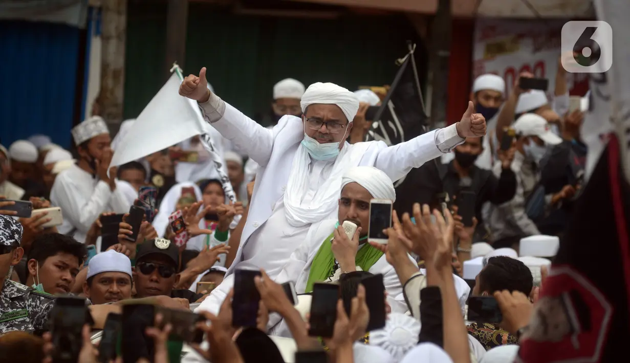 Rizieq Shihab menyapa massa pendukungnya saat tiba di kediamannya di Jalan Petamburan, Jakarta, Selasa (10/11/2020). Rizieq Shihab tiba di kediamannya usai pulang dari Arab Saudi. (merdeka.com/Imam Buhori)