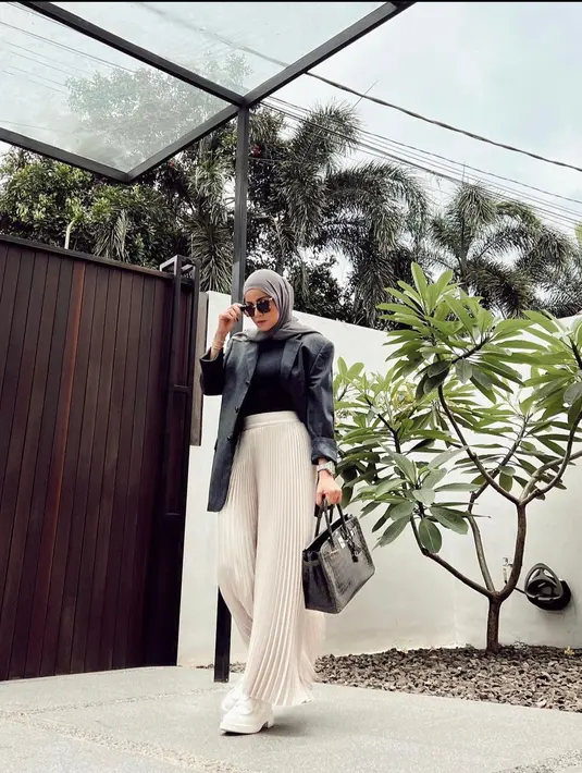 <p>Tampil monokrom dengan blazer hitam dan celana plisket berwarna off white. (instagram/ollaramlan)</p>