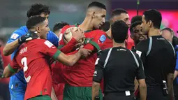 Sejumlah pemain Maroko yang tidak puas dengan kepemimpinan wasit menghampiri Abdulrahman Al Jassim selaku pengadil lapangan setelah peluit panjang babak kedua dibunyikan. (AP Photo/Francisco Seco)