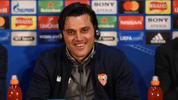 Pelatih Sevilla, Vincenzo Montella tersenyum saat konferensi pers di stadion Old Trafford di Manchester, Inggris (12/3). Sevilla akan melawan Manchester United pada leg kedua babak 16 besar Liga Champions. (AFP Photo/Oli Scarff)