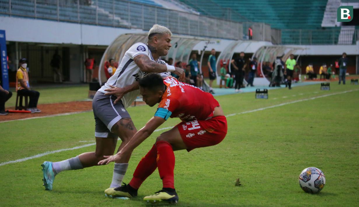 Penyerang Persib Bandung Ciro Alves (kiri) mencoba lepas dari penjagaan kapten Bali United Ricky Fajrin dalam pertandingan pekan ke-23 BRI Liga 1 2022/2023 di Stadion Maguwoharjo Sleman, Jumat (10/02/2023) WIB. (Bola.com/Maheswara Putra)