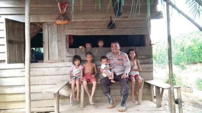 Personel Polres Indragiri Hulu bersama anak-anak dari Suku Talang Mamak. (Liputan6.com/M Syukur)