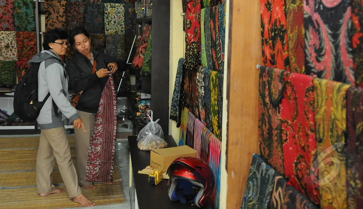 Seorang pengunjung tampak melihat-lihat batik yang dijajakan oleh para pengrajin batik, Sidoarjo, Jawa Timur, Selasa (24/3/2015). (Liputan6.com/Herman Zakharia)