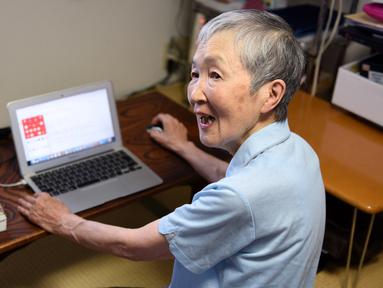 Masako Wakamiya (82) menggunakan laptop di rumahnya daerah Fujisawa, Prefektur Kanagawa, Jepang, 13 Juli 2017. Wakamiya kini menyandang predikat sebagai pengembang atau developer aplikasi berusia paling tua di raksasa gadget Apple. (Kazuhiro NOGI/AFP)