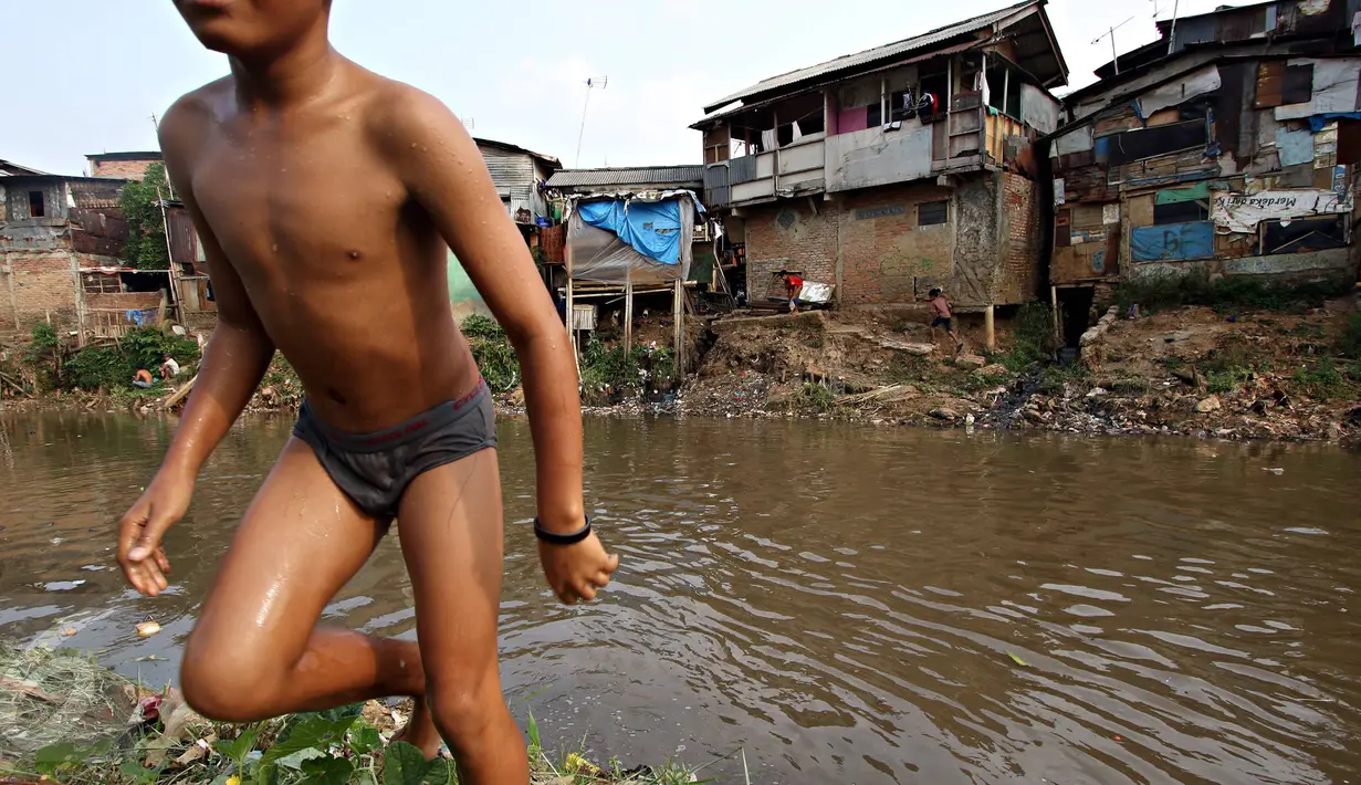 Seorang anak bermain di bantaran Sungai Ciliwung, Jakarta, Selasa (13/10/2015). Berdasarkan data BPS DKI Jakarta, angka kemiskinan di Jakarta tahun 2015 mengalami penurunan 0,16 persen dibandingkan tahun lalu. (Liputan6.com/Immanuel Antonius)