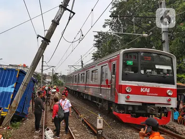 Petugas melakukan evakuasi truk yang menabrak tiang penyangga kabel KRL di antara Perlintasan Pondok Ranji - Kebayoran,Jakarta, Selasa (25/7/2023). (Liputan6.com/Angga Yuniar)