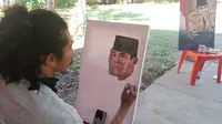 Foto: Salah satu pelukis saat melukis wajah Bung Karno yang digelar DPC PDIP Sikka, NTT (Liputan6.com/Ola Keda)