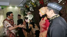 Cawagub DKI Jakarta Djarot Saiful Hidayat memberi ucapan selamat kepada pengantin di Petogogan I, Jakarta Selatan, Minggu (11/12). Djarot berpesan kepada warga untuk menjaga kebersihan dan lingkungan. (Liputan6.com/Fery Pradolo)