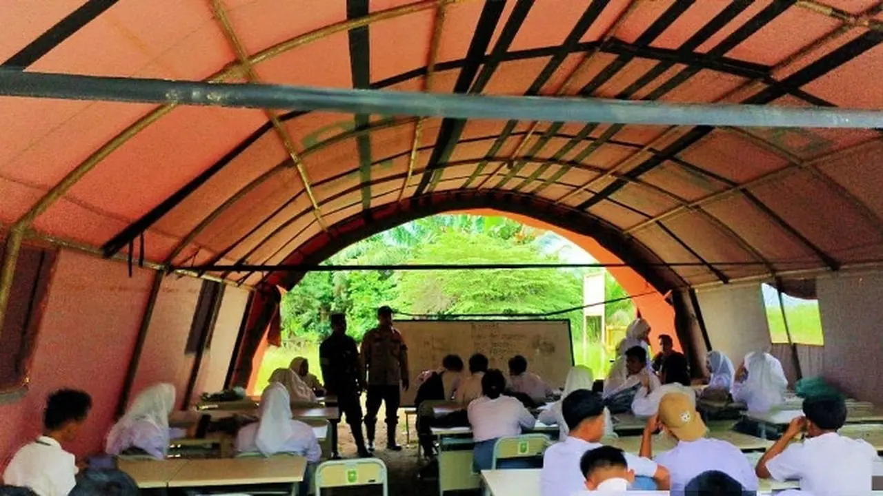 Banjir rendam sekolah di salah satu desa di Kabupaten Rokan Hulu membuat puluhan siswa belajar di tenda darurat.