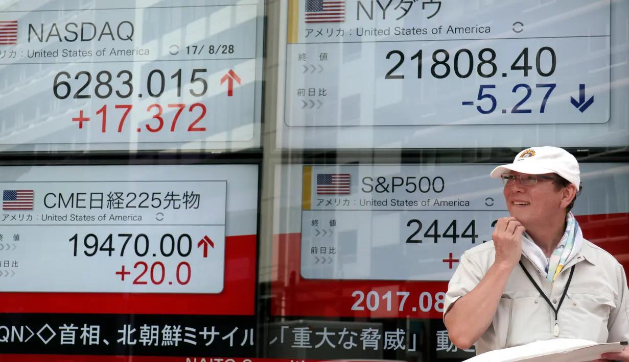 Seorang pria berdiri didepan indikator saham elektronik sebuah perusahaan sekuritas di Tokyo (29/8). Ketegangan politik yang terjadi karena Korut meluncurkan rudalnya mempengaruhi pasar saham Asia. (AP Photo/Shizuo Kambayashi)