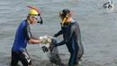 Prajurit TNI AL dengan pakaian selam membersihkan sampah di kawasan Pantai Ancol, Jakarta, Jumat (1/3). Sekitar 400 orang yang diterjunkan untuk membersihkan pesisir laut dengan garis pantai sepanjang 300 meter itu. (Merdeka.com/ Imam Buhori)