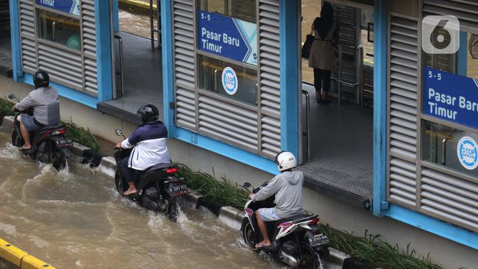 Pengendara motor nekat menerobos genangan banjir di Jalan Gunung Sahari Jakarta, Selasa (25/2/2020). Hujan yang mengguyur Jakarta sejak Senin (24/2) malam membuat sejumlah kali meluap dan menyebabkan banjir. (Liputan6.com/Helmi Fithriansyah)