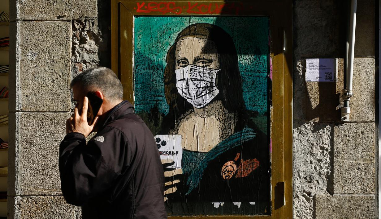 Seorang pria melewati poster seniman Italia TVBOY bergambar Mona Lisa karya Leonardo da Vinci mengenakan masker dan memegang smartphone di Barcelona, Selasa (18/2/2020). Instalasi muncul setelah Mobile World Congress (MWC) 2020 batal digelar karena wabah virus corona yang mencekam. (PAU BARRENA/AFP)