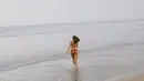 Terlihat seperti berlari menuju laut, Pamela Bowie mengenakan two-pieces bikin bernuansa merah-putih. Foto: Instagram.