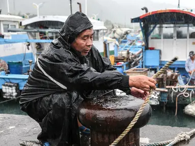 Seorang nelayan mengamankan perahunya saat Topan Kong-rey mendekati Taiwan, di wilayah Yilan pada 30 Oktober 2024. (I-Hwa CHENG/AFP)
