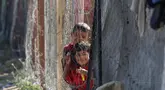 Anak-anak berdiri di samping tenda-tenda di kamp yang menampung para pengungsi Palestina di kamp Al-Bureij, Jalur Gaza tengah pada 7 Juli 2025. (Eyad BABA/AFP)