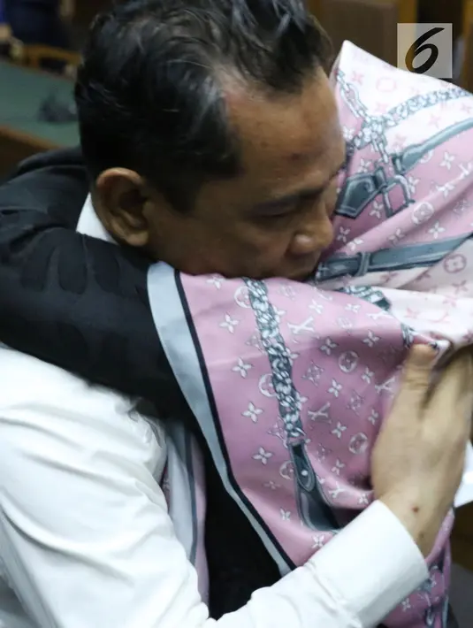 Bupati Hulu Sungai Tengah (HST) nonaktif, Abdul Latifdipeluk kerabatnya usai menjalani sidang tuntutan di Pengadilan Tipikor, Jakarta, Senin (6/8). JPU KPK menuntut hukuman 8 tahun penjara. (Liputan6.com/Helmi Fithriansyah)