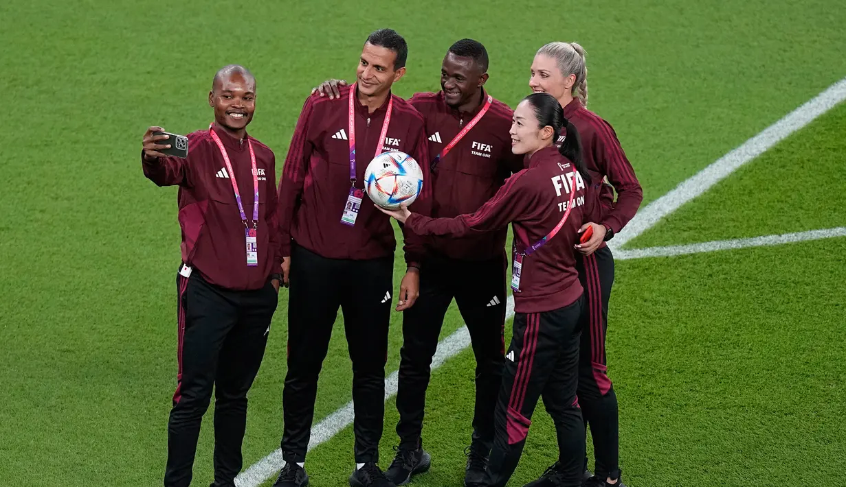Wasit Jepang Yoshimi Yamashita (kanan) berfoto di lapangan sebelum pertandingan sepak bola grup F Piala Dunia antara Belgia dan Kanada, di Stadion Ahmad Bin Ali, Doha, Qatar, Rabu (23/11/2022). Untuk pertama kalinya wasit perempuan memimpin pertandingan pria di Piala Dunia FIFA. (AP Photo/Ariel Schalit)