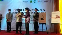 Imam Besar Masjid Istiqlal, Nasaruddin Umar memberikan buku karyanya kepada Menko Polhukam Mahfud Md. (Liputan6com/Yopi Makdori)