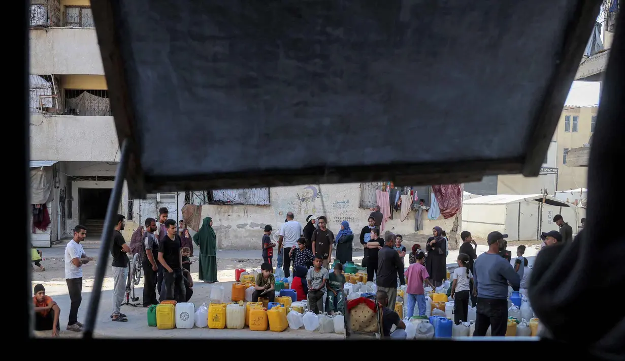 Orang-orang yang terlantar akibat perang menunggu dengan wadah air untuk mengisi persediaan mereka dari tangki air di kamp penampungan, Khan Yunis, Jalur Gaza Selatan pada 6 Juni 2026. (Bashar Taleb/AFP)