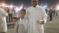 Dua Qatari atau orang asli Qatar yang bagi-bagi kurma dan karak tea di depan Ahmed bin Ali Stadium. (Hendry Wibowo/Bola.com)