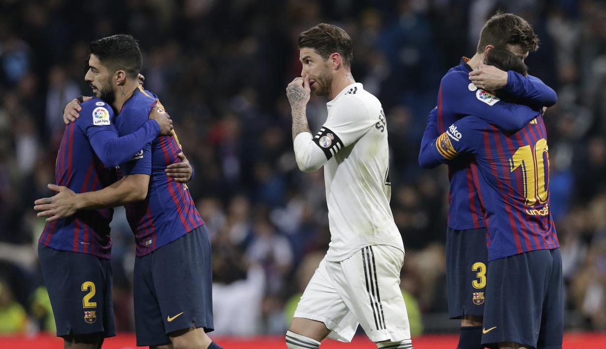 Bek Real Madrid, Sergio Ramos, melintas diantara pemain Barcelona pada laga La Liga di Stadion Santiago Bernabeu, Sabtu (2/3). Real Madrid takluk 0-1 dari Barcelona. (AP/Andrea Comas)