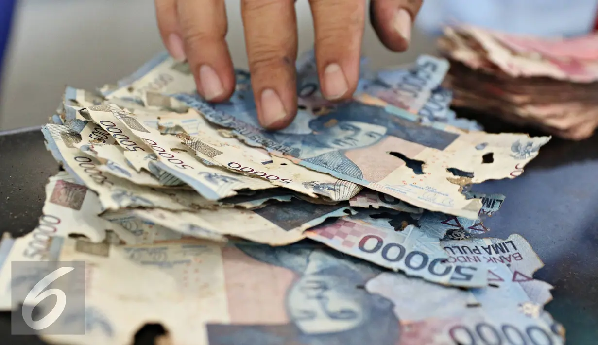 Sejumlah uang rusak yang ditukarkan warga di Bank Indonesia, Jakarta, Senin (6/6). Syarat penukaran uang meliputi keaslian uang, masih terdapat nomor seri, dan masih tersisa minimal 2/3 bagian dari bentuk uang. (Liputan6.com/Immanue Antonius)