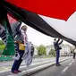 Orang-orang memegang bendera Palestina saat mereka berbaris dalam solidaritas untuk rakyat Palestina di tengah konflik yang sedang berlangsung dengan Israel selama demonstrasi di London, Inggris, Sabtu (15/5/2021). (AP Photo/Alberto Pezzali)