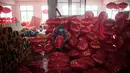 Seorang pekerja sedang melipat lampion merah menjelang perayaan Tahun Baru Imlek di provinsi Hebei, Tingkok (11/1). Dalam persiapan perayaan terbesar di Tiongkok ini, mereka membuat lampion selama lebih dari sebulan. (AFP Photo/Fred Dufour)