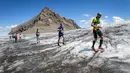 Peserta berlari menaiki bukit di Glacier Tsanfleuron saat mengikuti Glacier 3000 Run and Marathon di Les Diablerets, Swiss (5/8). Acara lomba lari yang melintasi pegungunan salju ini diikuti 1.200 peserta. (AFP Photo/ Fabrice Coffrini)