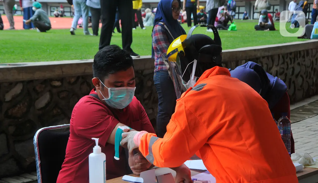 Petugas mengambil sampel darah saat melakukan rapid test pendeteksian COVID-19 kepada tenaga medis di Stadion Patriot Candrabhaga, Bekasi, Rabu (25/3/2020). Pemeriksaan hanya diperuntukan bagi tenaga medis seluruh puskesmas, dan rumah sakit yang ada di Kota Bekasi. (Liputan6.com/Herman Zakharia)