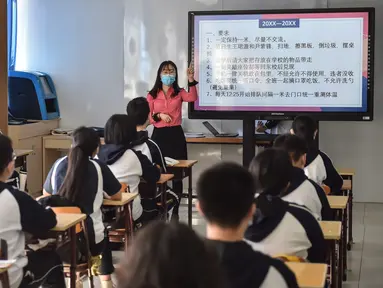 Para siswa belajar peraturan pencegahan dan pengendalian wabah Covid-19 di Sekolah Menengah No. 166, Beijing (11/5/2020). Beijing pada Senin (11/5) memulai kembali kegiatan belajar di kelas untuk siswa tingkat akhir di seluruh sekolah menengah pertama seiring meredanya Covid-19. (Xinhua/Peng Ziyang)