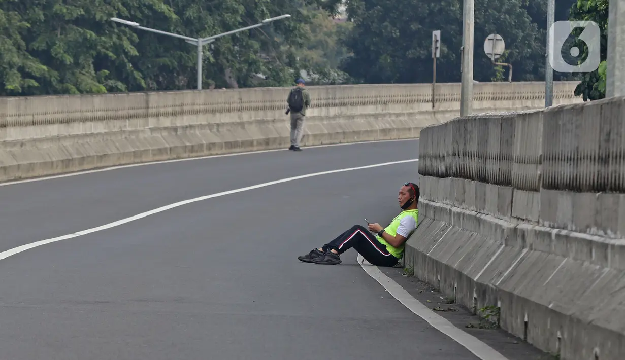 Warga beristirahat saat Hari Bebas Kendaraan Bermotor (HBKB) atau Car Free Day (CFD) di Jalan Layang Non Tol Antarasari, Jakarta, Minggu (28/6/2020). (Liputan6.com/Herman Zakharia)