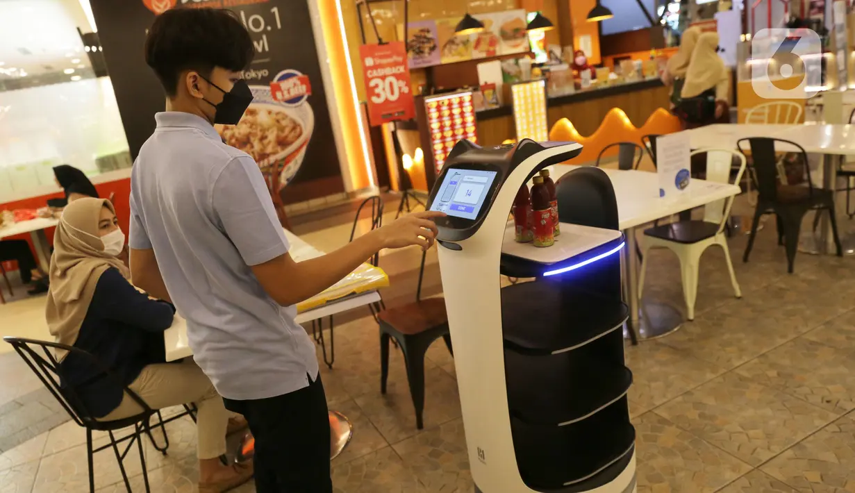 Seseorang berinteraksi dengan robot pramusaji “Bellabot” yang mengantar makanan di Tangcity Mal, Kota Tangerang, Rabu (27/10/2021). Robot karakter hewan itu melayani antar pesan makanan bagi pengunjung guna mengurangi interaksi mengingat masih dalam pandemi covid-19. (Liputan6.com/Angga Yuniar)