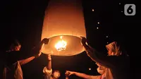 Peserta menerbangkan lampion sebagai tanda puncak perayaan Tri Suci Waisak 2566 BE/2022 di Candi Borobudur, Magelang, Jawa Tegah, Senin (16/05/2022) malam. Sebanyak 2022 lampion diterbangkan oleh biksu, umat Buddha serta wisatawan sebagai simbol harapan dan perdamaian untuk dunia. (merdeka.com/Iqbal S.Nugroho)