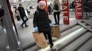 Seorang perempuan membawa dua kantong belanja meninggalkan toko H&M pada hari terakhir pembukaan di Moskow, Rusia, Rabu (30/11/2022). H&M menutup seluruh tokonya sebagai bentuk protes atas serangan Rusia ke Ukraina.  (AP Photo/Alexander Zemlianichenko)
