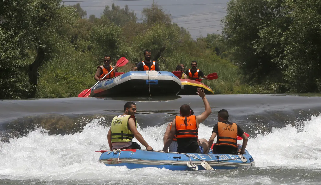 Umat muslim merayakan liburan Idul Fitri dengan rafting menyusuri Sungai Hasbani, Anak Sungai Yordan, di Kfar Blum, Israel, Rabu (27/5/2020). Pemerintah Israel mengurangi pembatasan aktivitas terkait pandemi virus corona COVID-19. (JALAA MAREY/AFP)