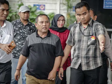 Asisten III Pemprov Jambi Syaifuddin (tengah), Anggota DPRD Jambi Nurhayati (belakang) dikawal petugas memasuki Gedung KPK, Jakarta, Rabu (29/11). KPK melakukan operasi tangkap tangan di Provinsi Jambi. (Liputan6.com/Faizal Fanani)