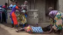 Reaksi kerabat setelah tim medis membawa jenazah korban Ebola dari sebuah rumah di Waterloo, Sierra Leone, 7 Oktober 2014. Inggris mengirimkan personel militer ke Sierra Leone untuk membantu memerangi penyebaran virus Ebola. (AFP PHOTO/FLORIAN PLAUCHEUR)