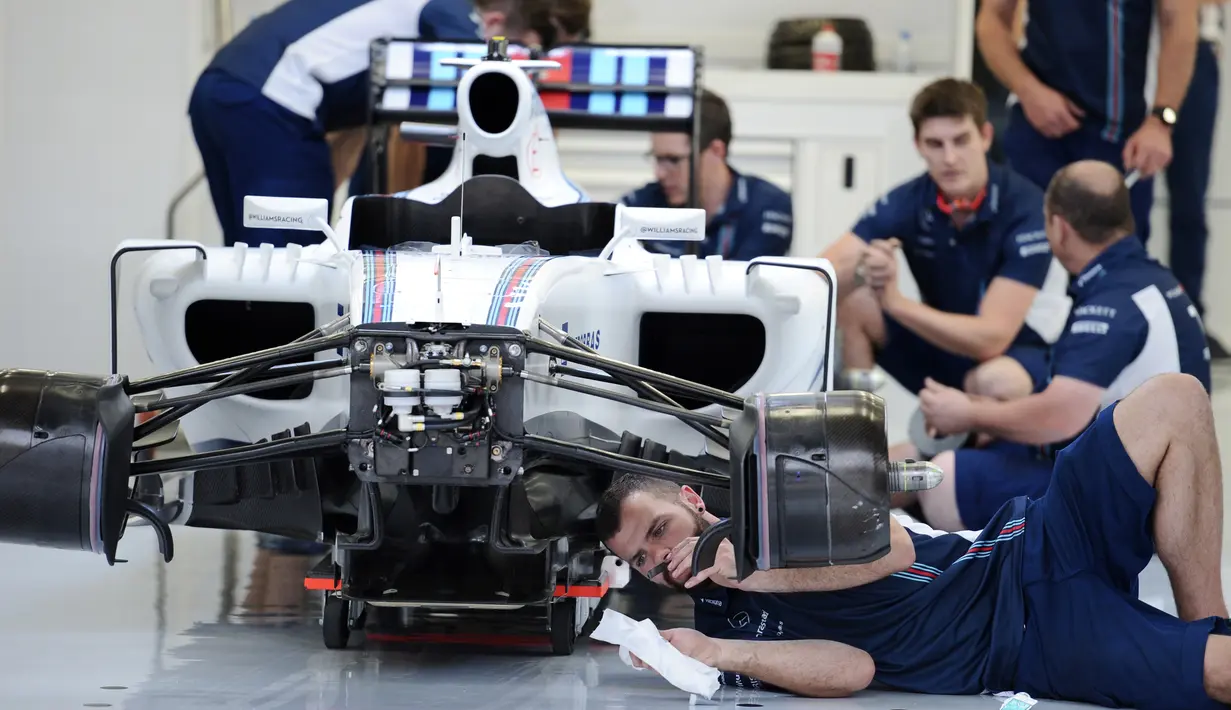 Tim Williams Martini Racing merakit mobil Formula 1 di Sirkuit Sakhir, Bahrain (31/3). jelang Grand Prix F1 Bahrain, Sejumlah tim sibuk mempersiapkan mobil terbaiknya masing-masing. (AFP PHOTO/MOHAMMED AL-SHAIKH)