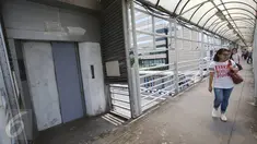 Warga melintas di depan lift khusus lansia dan ibu hamil yang rusak di JPO Sarinah, Jakarta, Kamis (2/3). Kurangnya perhatian pihak terkait menyebabkan lift tersebut menjadi terbengkalai serta tidak berguna. (Liputan6.com/Immanuel Antonius)