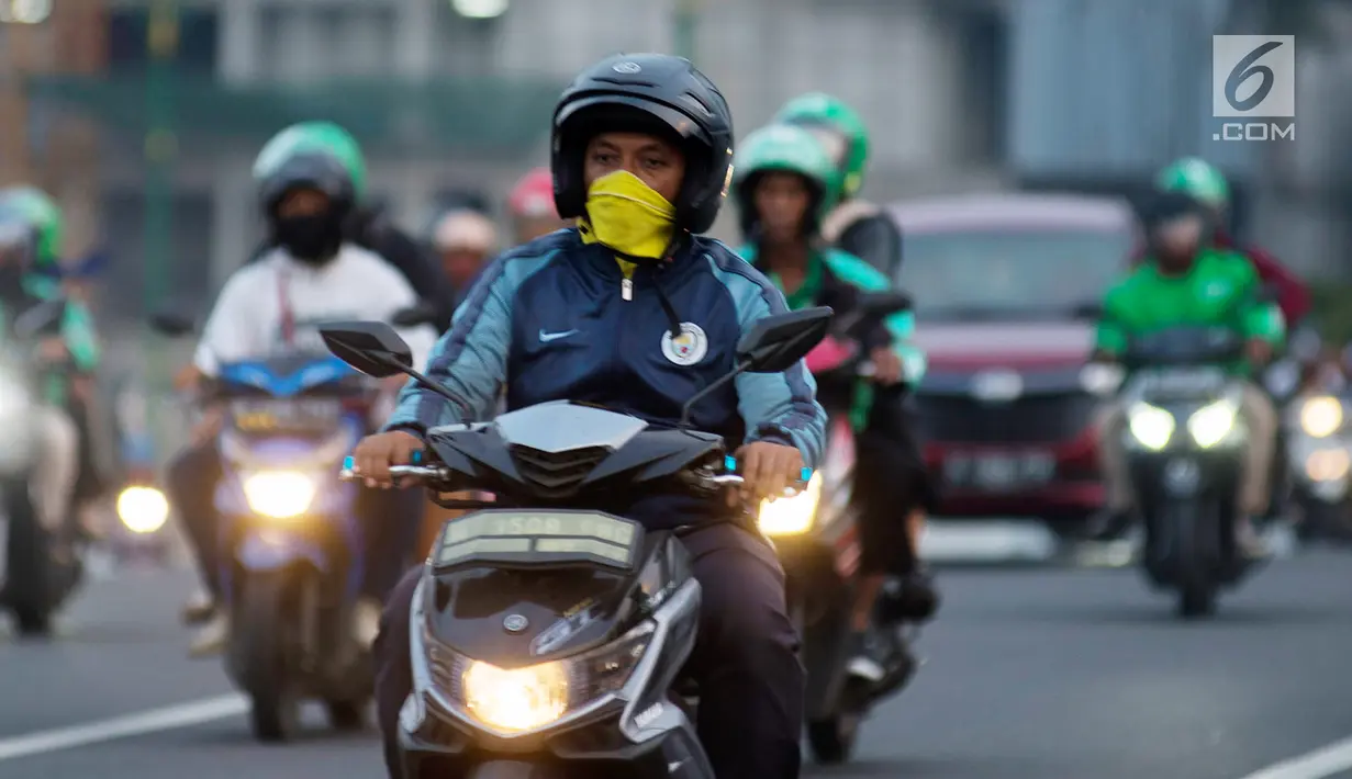 Pengendara sepeda motor mengenakan masker saat berkendara di Jakarta, Kamis (4/7/2019). Organisasi lingkungan Greenpeace menyatakan kualitas udara Jakarta saat ini terpantau sangat tidak sehat dengan angka 165 AQI atau Indeks Kualitas Udara. (merdeka.com/Imam Buhori)