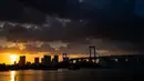 The Rainbow Bridge terlihat saat matahari terbenam di Tokyo, Jepang (29/7). Odaiba merupakan salah satu tujuan wisata di Tokyo, sekaligus lokasi pusat perbelanjaan dan permukiman. (AFP Photo/Martin Bureau)