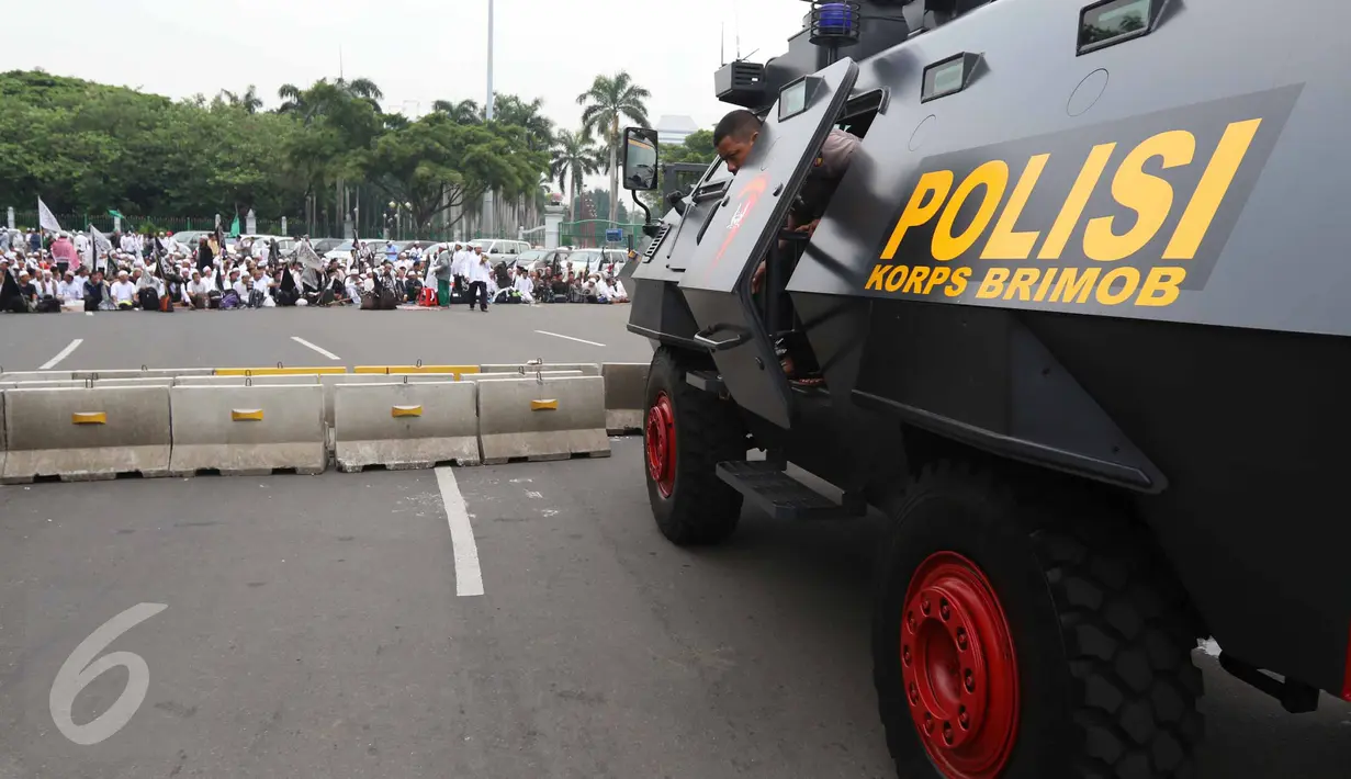 Massa aksi damai 4 November bersiap menggelar salat Jumat di Jalan Merdeka Barat, Jakarta, Jumat (4/11). Sejumlah aparat kepolisian dan mobil barakuda disiagakan berhadapan dengan massa pendemo. (Liputan6.com/Faizal Fanani)