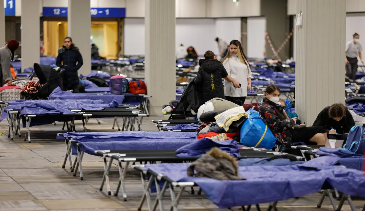 Pengungsi duduk di tempat tidur di pusat pengungsi yang tiba dari Ukraina di Messe di Berlin, Jerman pada 11 Maret 2022. Badan PBB untuk urusan pengungsi (UNHCR) mengatakan setidaknya 2,5 juta orang telah meninggalkan Ukraina, dengan lebih dari setengahnya sekarang di Polandia. (Odd ANDERSEN / AFP)