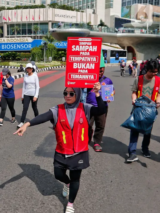 Relawan 'Operasi Semut' dari berbagai komunitas mengajak para pengunjung CFD untuk memungut sampah di Kawasan Bundaran HI, Jakarta, Minggu (19/2/2023). Aksi memungut sampah tersebut merupakan kampanye memperingati 'Hari Peduli Sampah Nasional dan Hari Bersih Indonesia 2023'. (Liputan6.com/Angga Yuniar)