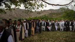 Teman dan kerabat menghadiri pemakaman jenazah kepala fotografer Agence France Presse (AFP) Afghanistan Shah Marai Faizi di Gul Dara, Kabul (30/4). Ledakan tersebut menewaskan 25 orang, di antara korban merupakan para wartawan.(Andrew Quilty / POOL / AFP)