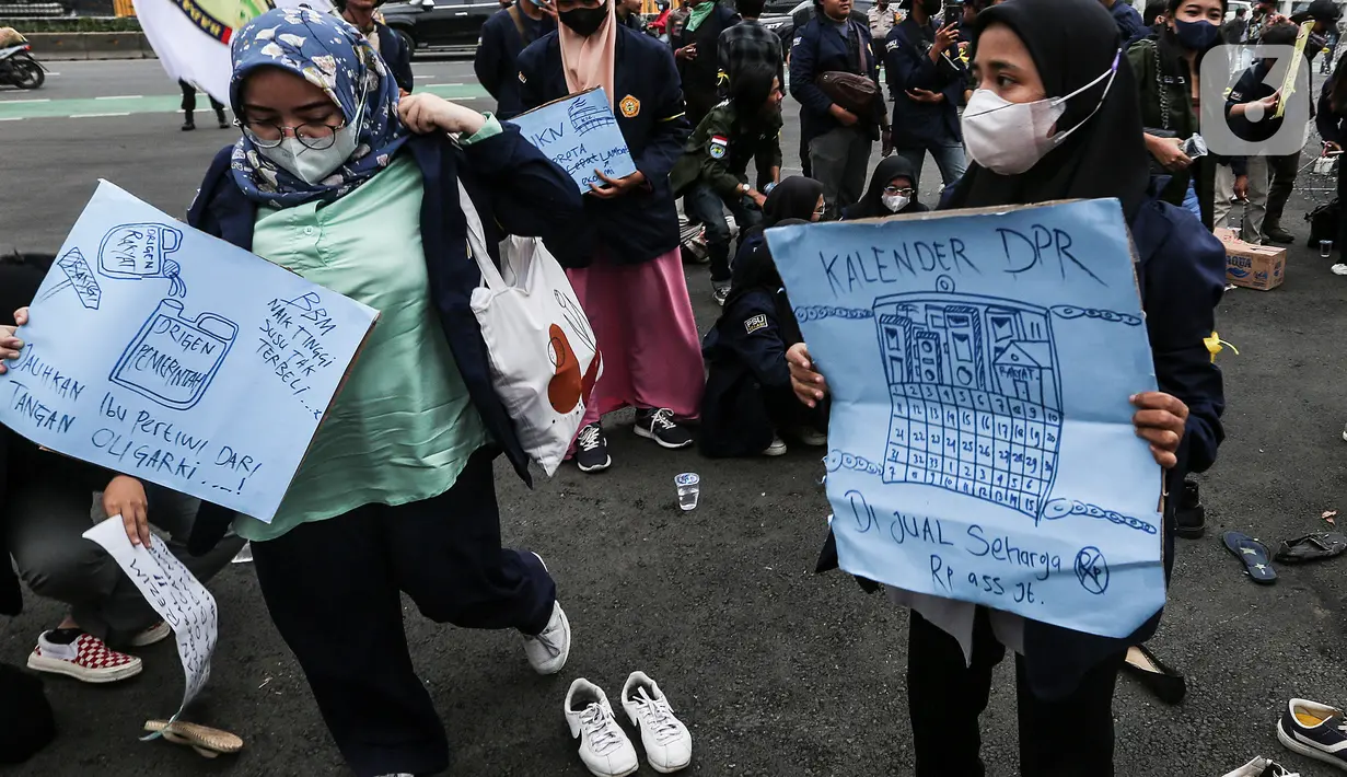 Mahasiswa membawa poster saat demo teatrikal di depan Gedung DPR/MPR RI, Jakarta Pusat, Jumat (9/9/2022). Demo tersebut untuk menolak kebijakan pemerintah menaikkan harga BBM. (Liputan6.com/Johan Tallo)