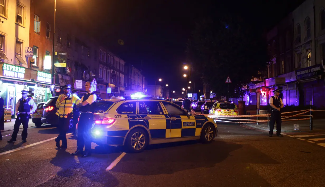 Petugas kepolisian menutup kawasan Finsbury Park di utara London usai insiden kendaraan yang menabraki pejalan kaki, Senin (19/6). Kepolisian Metropolitan London menyebut ada korban dalam insiden kendaraan yang menabraki pejalan kaki. (Yui Mok/PA via AP)